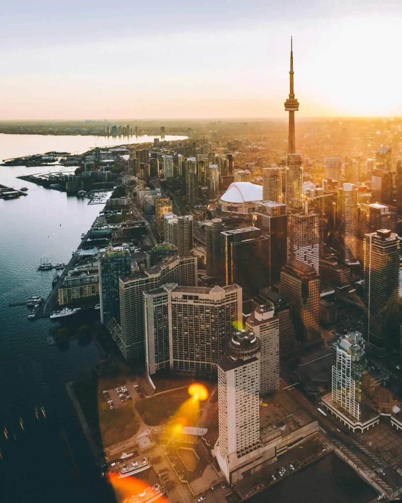 An aerial view of Toronto's skyline at sunset, featuring the CN Tower, high-rise buildings, and Lake Ontario waterfront taken by best local SEO agency in Toronto.